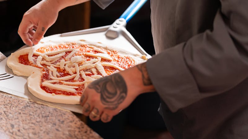 Pizza factory kitchen with handcrafted pizza dough being prepared